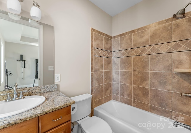 full bathroom with vanity, tiled shower / bath combo, and toilet