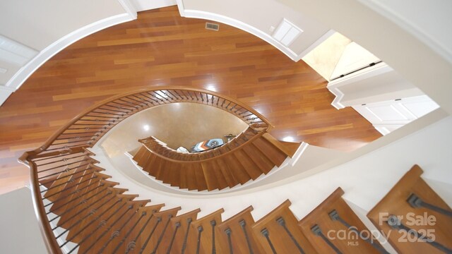 stairway with wood finished floors and visible vents