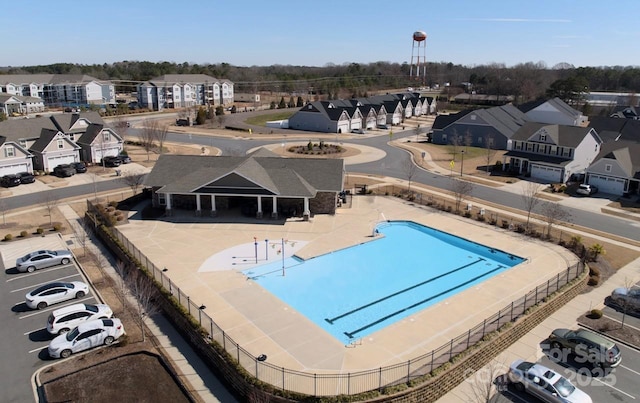 view of swimming pool with a residential view and fence