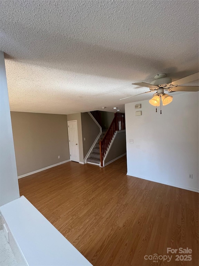 unfurnished room featuring a textured ceiling, wood-type flooring, and ceiling fan