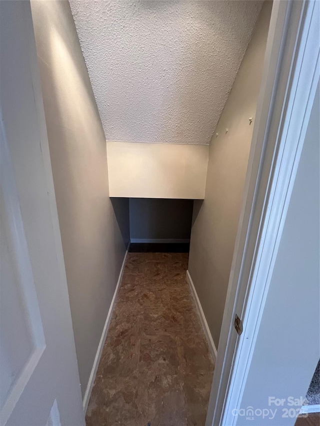 interior space with vaulted ceiling and a textured ceiling