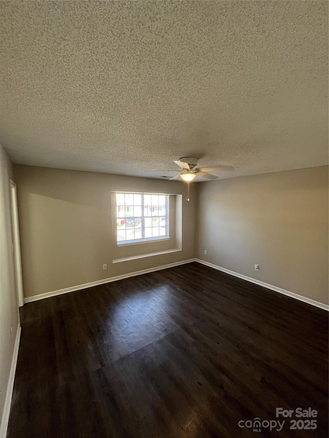 spare room with dark wood-type flooring, ceiling fan, and a textured ceiling