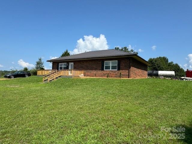 back of property with a wooden deck and a lawn