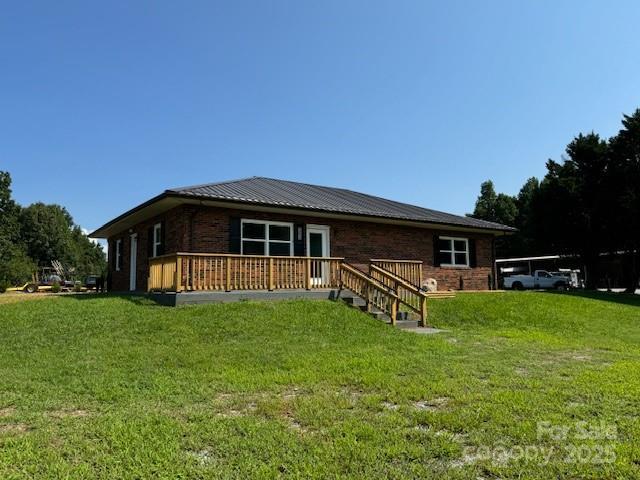 rear view of house with a deck and a lawn