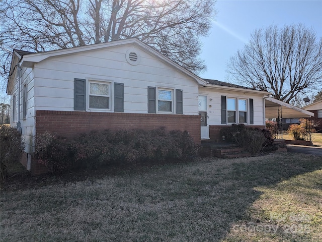 single story home featuring a carport and a front lawn