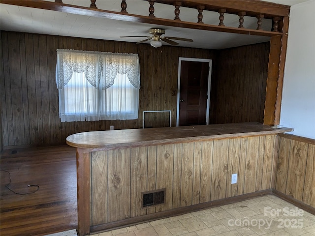 interior space with ceiling fan and wood walls