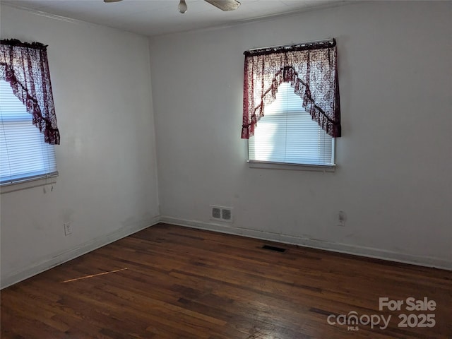 spare room featuring dark wood-type flooring and ceiling fan