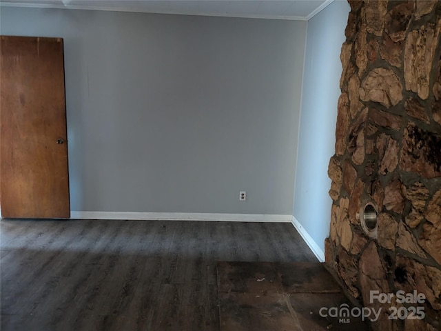 spare room featuring crown molding and dark wood-type flooring