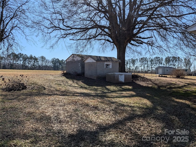 view of yard with a rural view and a shed