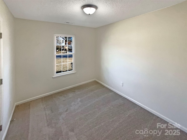 carpeted empty room featuring a textured ceiling