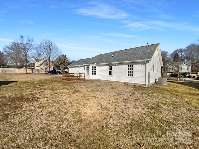 back of property featuring a lawn, central air condition unit, and a deck