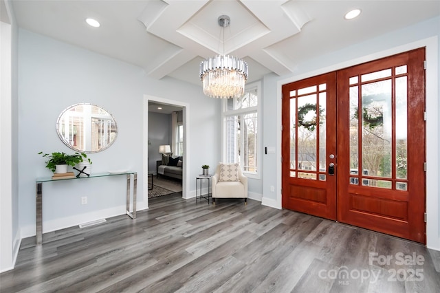 entrance foyer featuring hardwood / wood-style floors, coffered ceiling, beamed ceiling, french doors, and a chandelier