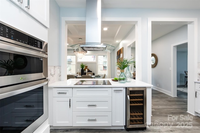 kitchen with double oven, wine cooler, black electric stovetop, wood-type flooring, and white cabinets