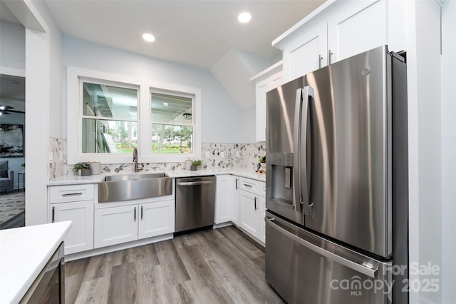 kitchen featuring sink, backsplash, white cabinets, and appliances with stainless steel finishes