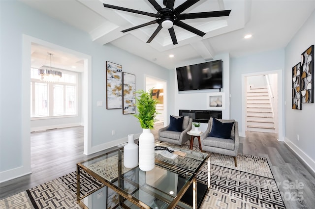 living room featuring hardwood / wood-style floors, beam ceiling, and ceiling fan with notable chandelier