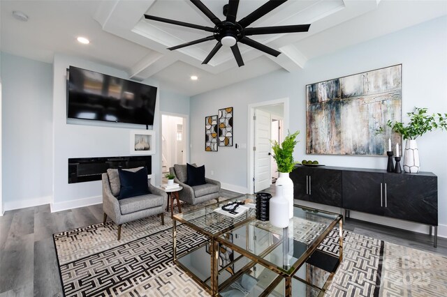 living room featuring coffered ceiling, ceiling fan, wood-type flooring, and beamed ceiling