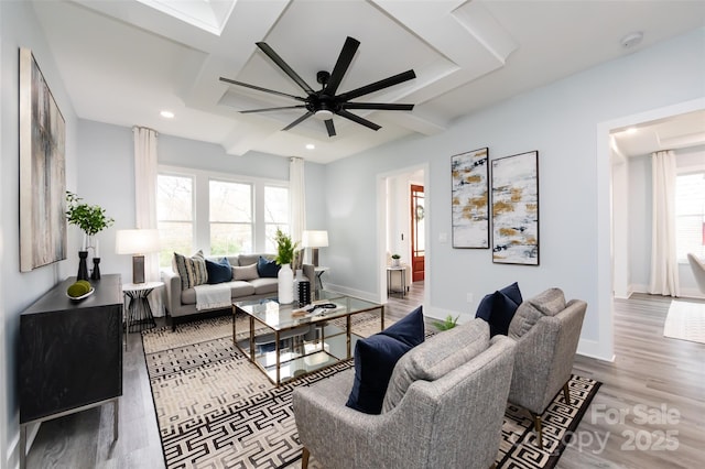 living room featuring beamed ceiling, wood-type flooring, and ceiling fan