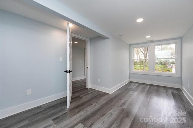 unfurnished room with dark wood-type flooring