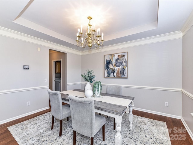 dining room with dark wood-style floors, baseboards, a raised ceiling, and a notable chandelier