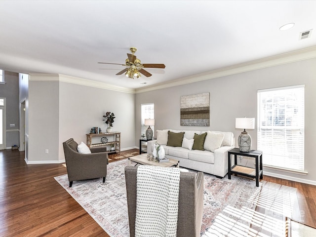 living room with visible vents, crown molding, baseboards, and wood finished floors