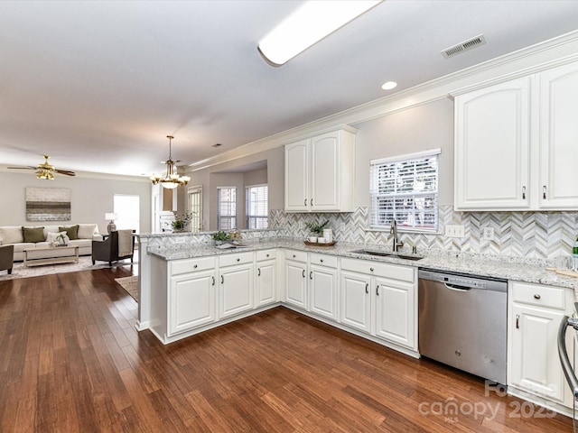 kitchen with white cabinets, dishwasher, open floor plan, a peninsula, and a sink