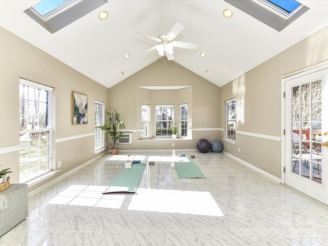 workout area featuring plenty of natural light, marble finish floor, a skylight, and baseboards