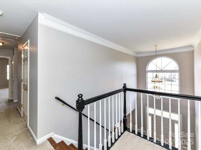 hallway with ornamental molding, carpet, an upstairs landing, and baseboards