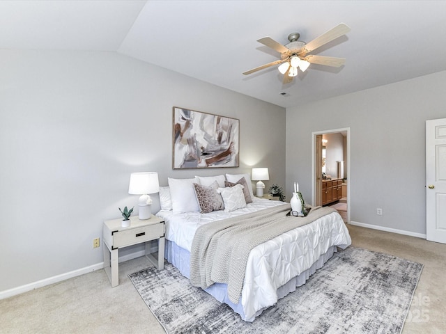 carpeted bedroom featuring ceiling fan, baseboards, vaulted ceiling, and ensuite bathroom