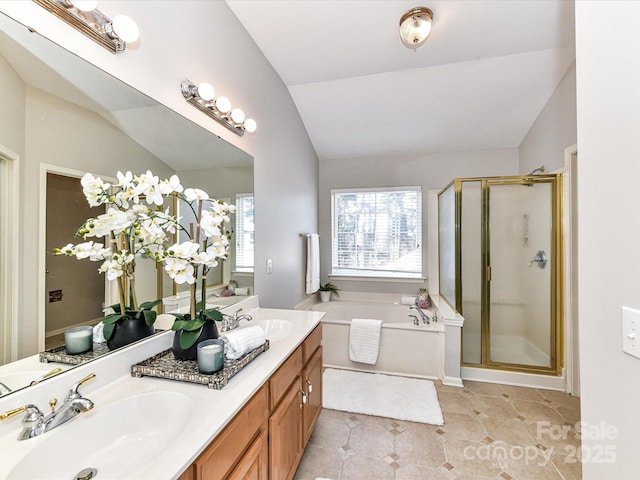 bathroom featuring vaulted ceiling, a sink, and a bath