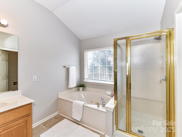 bathroom with a shower stall, vaulted ceiling, a bath, and vanity