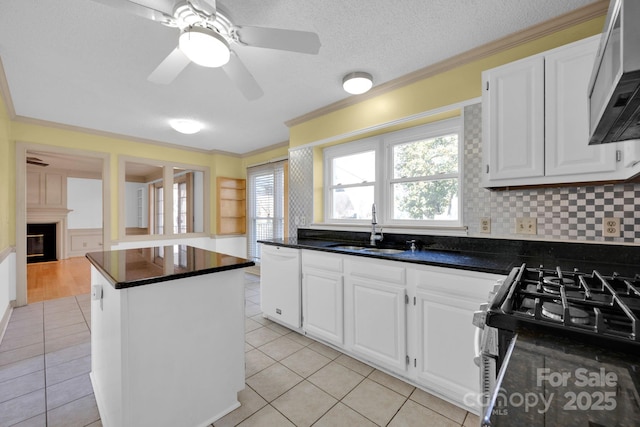 kitchen with sink, dishwasher, gas stove, white cabinets, and a kitchen island