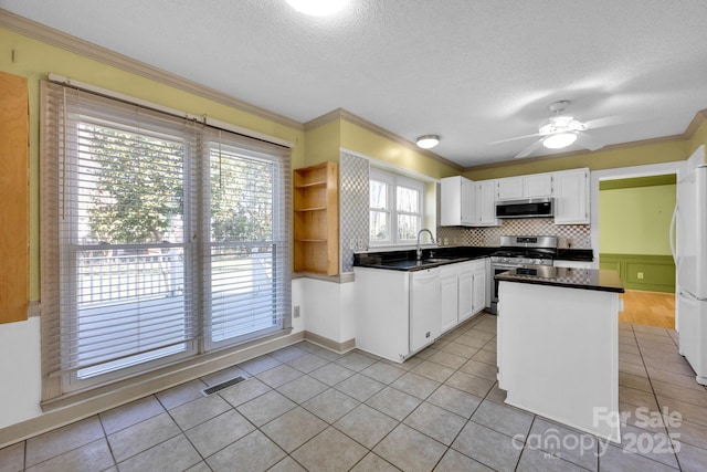 kitchen with sink, appliances with stainless steel finishes, white cabinetry, ornamental molding, and a textured ceiling