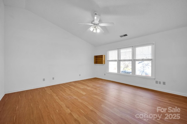 empty room featuring lofted ceiling, light hardwood / wood-style floors, and ceiling fan