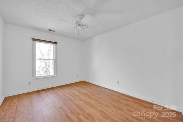 empty room featuring ceiling fan, a textured ceiling, and light wood-type flooring