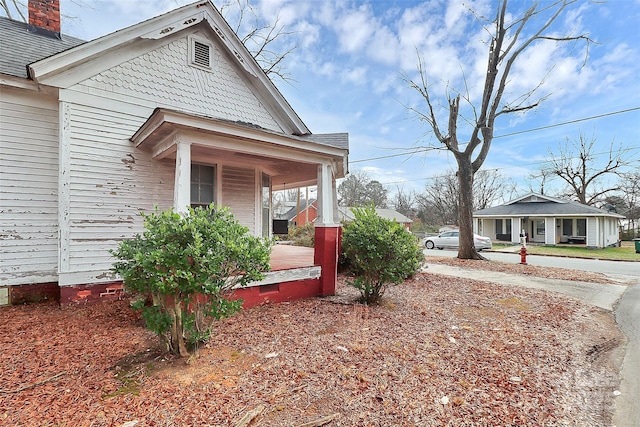 view of side of property with covered porch