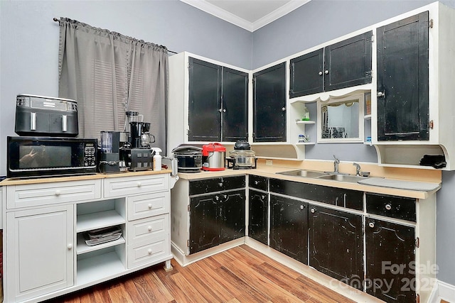 kitchen with sink, crown molding, and light hardwood / wood-style flooring