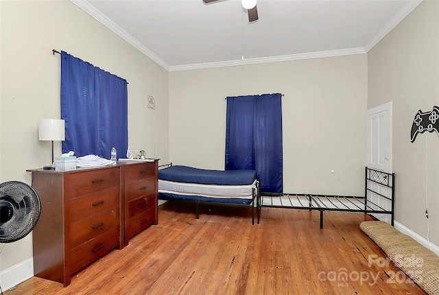 bedroom featuring ceiling fan, ornamental molding, and light wood-type flooring