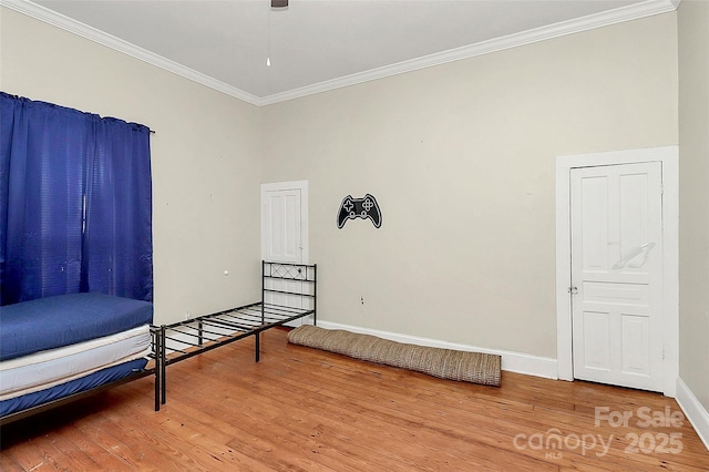 sitting room featuring a high ceiling, ornamental molding, and hardwood / wood-style floors