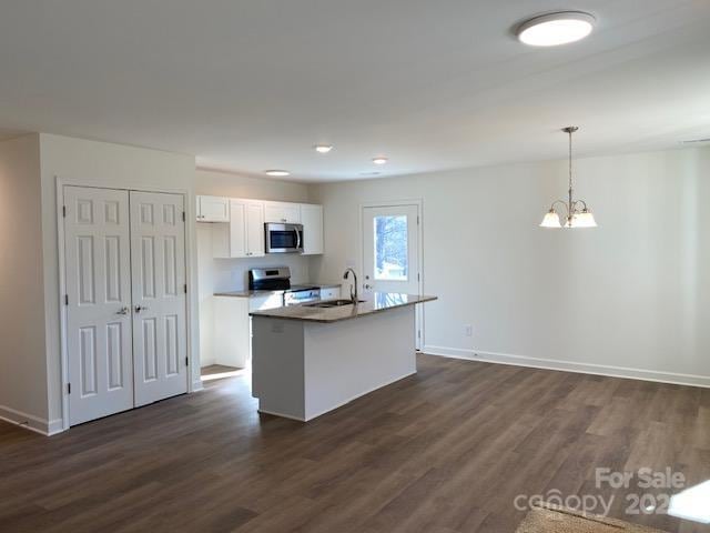 kitchen featuring sink, white cabinetry, decorative light fixtures, an island with sink, and stainless steel appliances