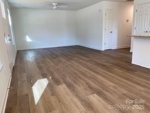 empty room with ceiling fan and dark hardwood / wood-style floors