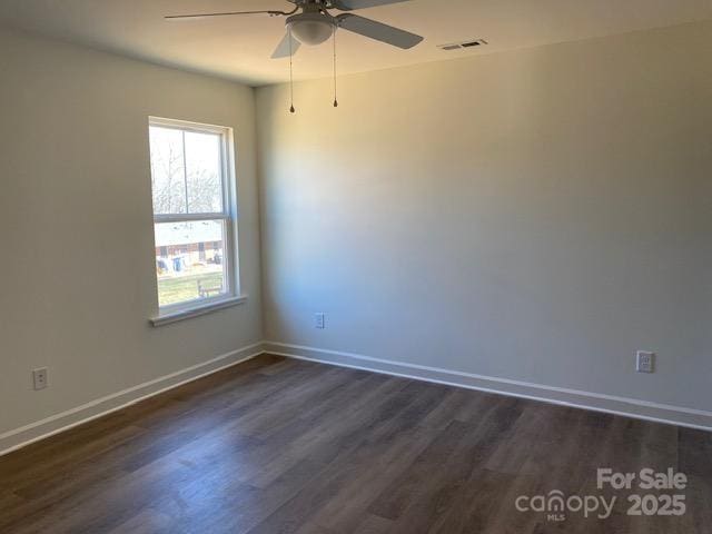 empty room with ceiling fan and dark hardwood / wood-style flooring