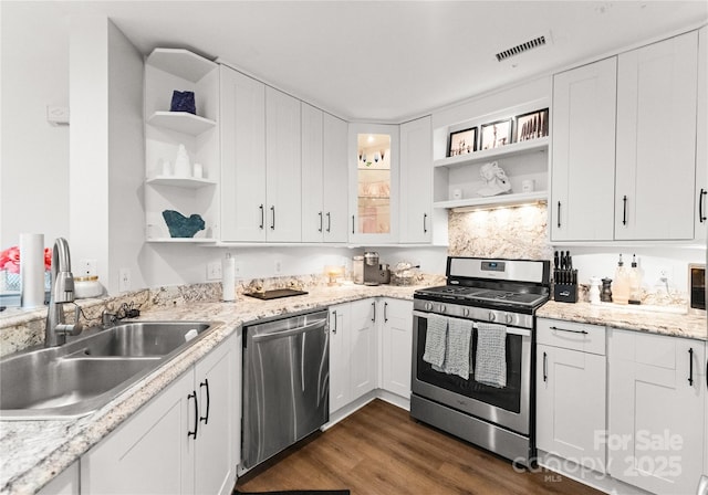 kitchen with dark wood-style floors, open shelves, stainless steel appliances, white cabinetry, and a sink