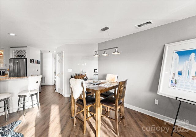 dining room featuring baseboards, visible vents, dark wood finished floors, and recessed lighting