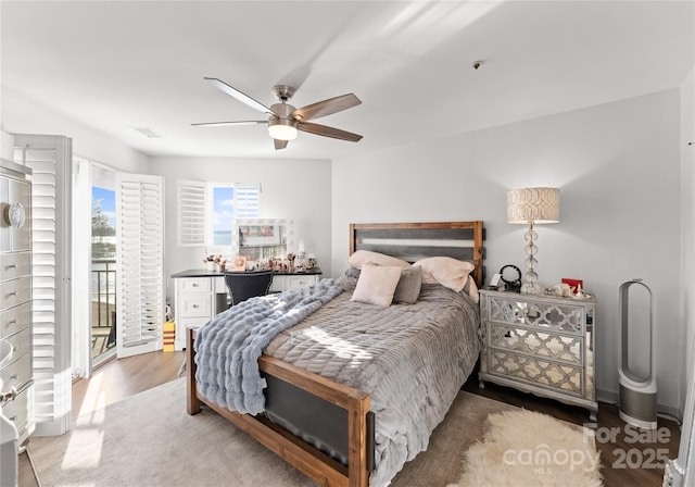 bedroom featuring ceiling fan, wood finished floors, and access to exterior