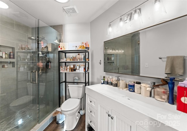 full bath featuring visible vents, toilet, a stall shower, vanity, and wood finished floors