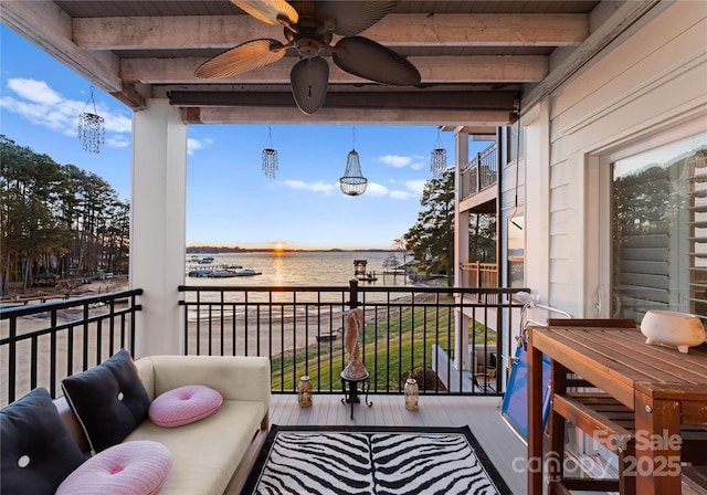 balcony with a water view and a ceiling fan