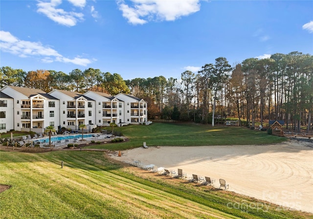 view of home's community featuring a lawn and a pool