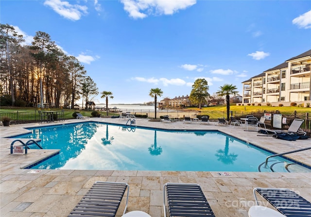 community pool featuring fence and a patio