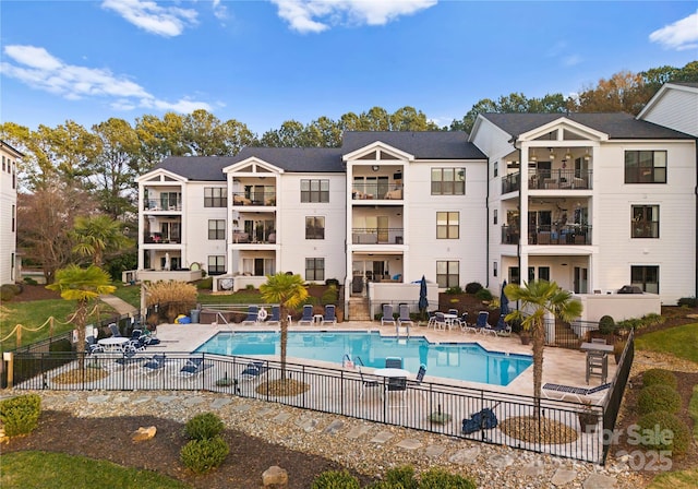 pool with a patio and fence