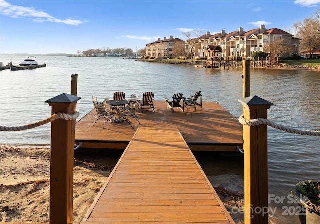 view of dock with a water view and a residential view